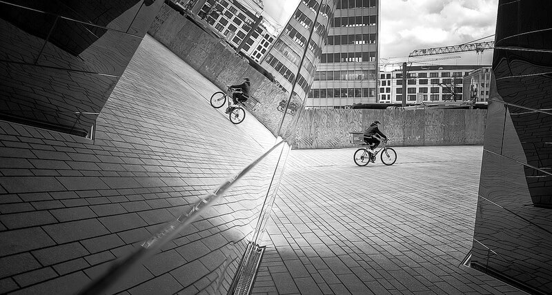 cyclist reflected in a glass building