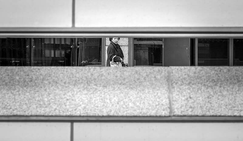 woman in a metro station viewed through a gap