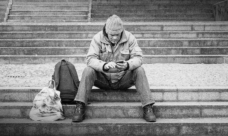 Man using his phone sitting on a staircase