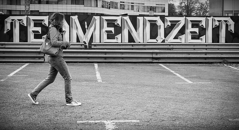 woman walking in front of a sign
