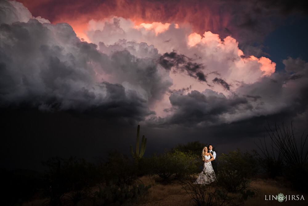 Couple poses under a cloudy sky