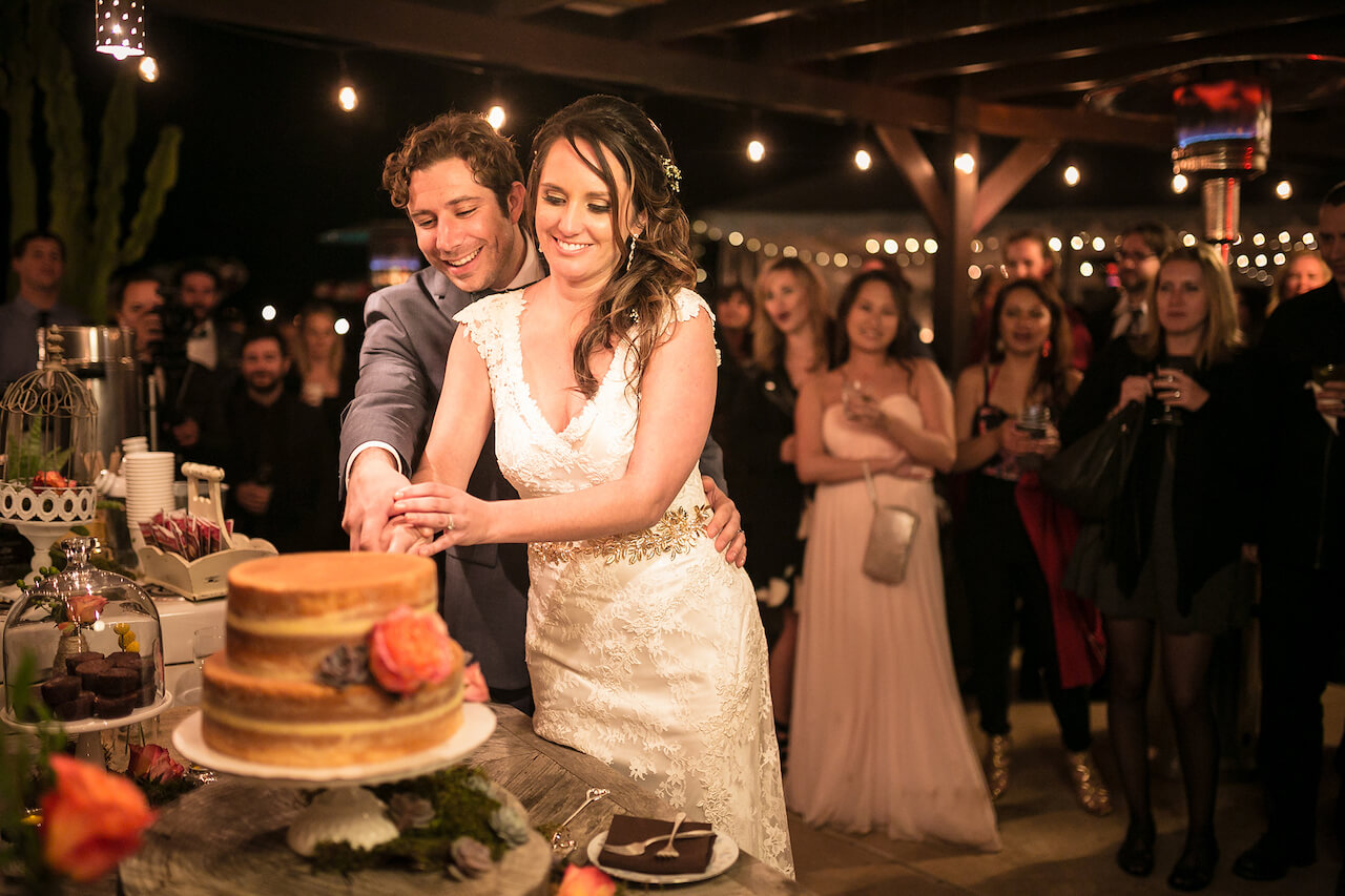 couple cuts cake for wedding cake pictures